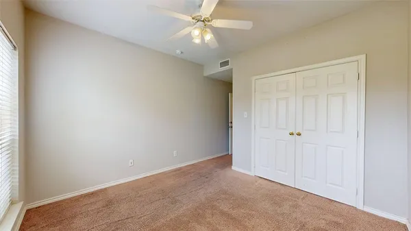 an empty room with closet and a window