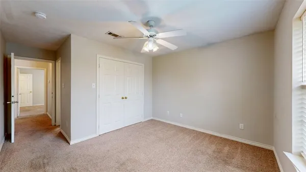 a view of an empty room and a ceiling fan