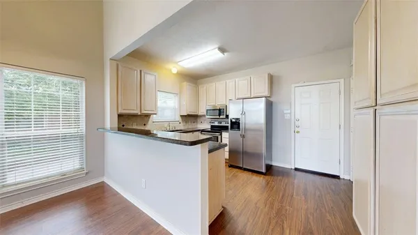 a kitchen with a refrigerator a sink and cabinets