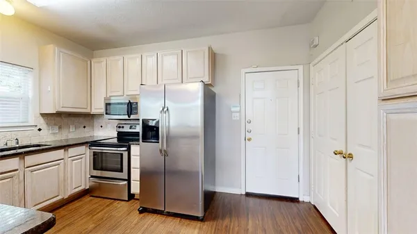 a kitchen with a refrigerator sink and cabinets