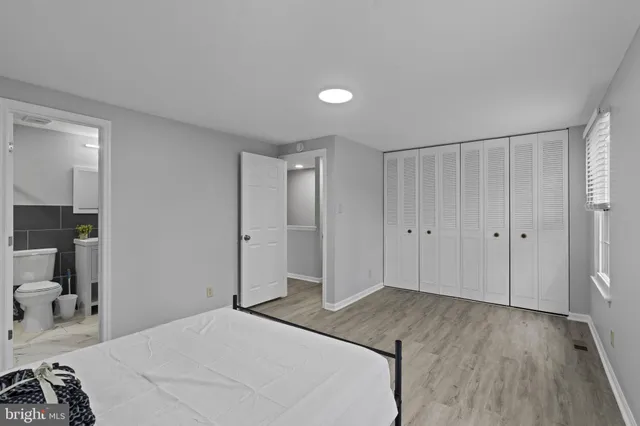 a spacious bedroom with a bed and a view of bathroom