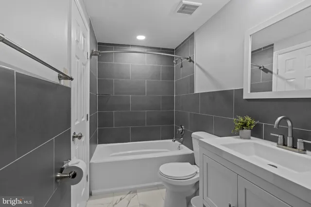 a bathroom with a sink mirror toilet and bathtub
