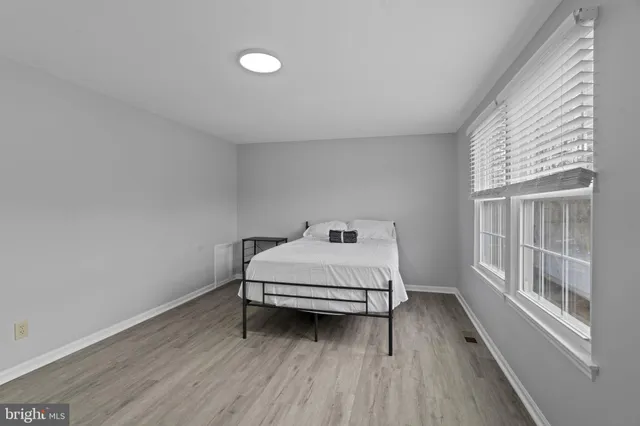 a bedroom with a bed and a large window