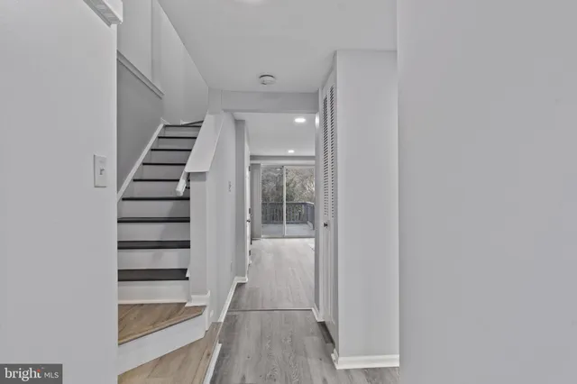 a view of a hallway with stairs and wooden floor