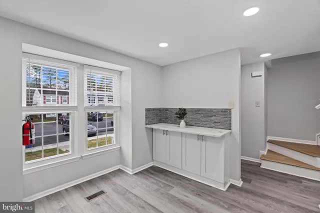 an empty room with wooden floor and window