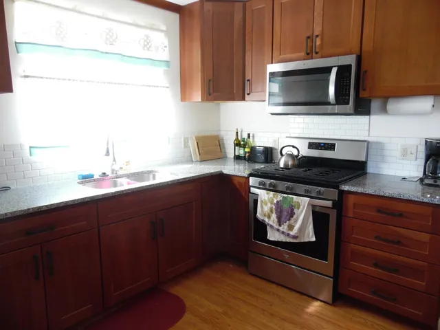 a kitchen with granite countertop a refrigerator stove and sink