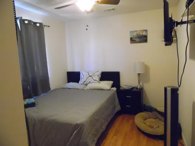 a bedroom with a bed and teddy bear on bed