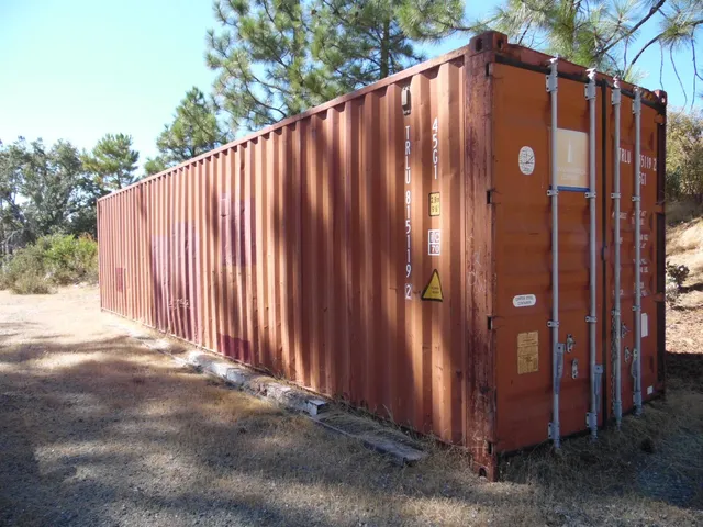 a view of a house with backyard and wooden fence
