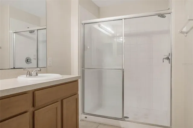 a bathroom with a shower sink and mirror