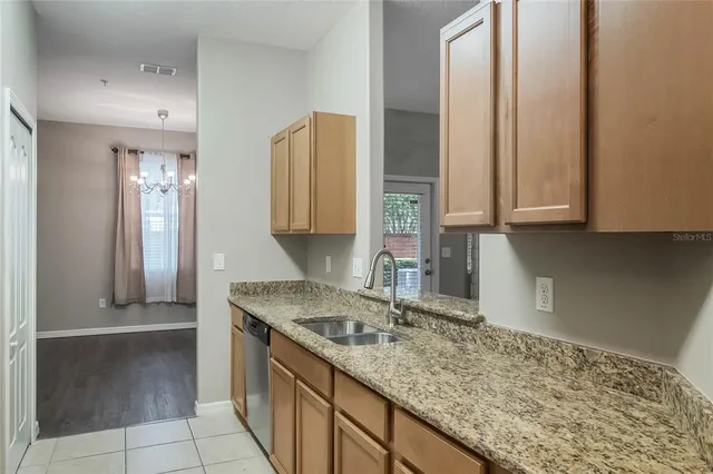 a kitchen with stainless steel appliances granite countertop a sink and a white cabinets