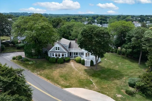 a view of a house with a yard and a large tree