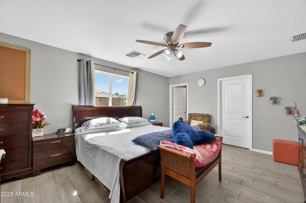 a bedroom with a bed and a flat tv screen on dresser