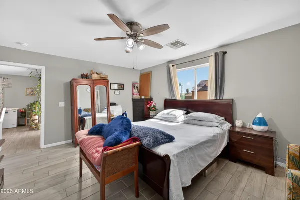 a bedroom with a bed a window and a dresser