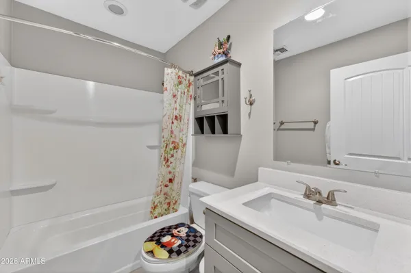 a bedroom with a bed a chair and a ceiling fan