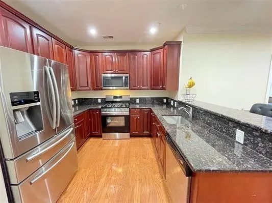 a kitchen with stainless steel appliances granite countertop a sink stove and refrigerator