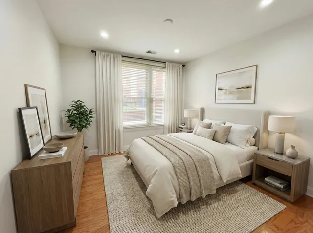 a bedroom with a bed a couch and potted plant