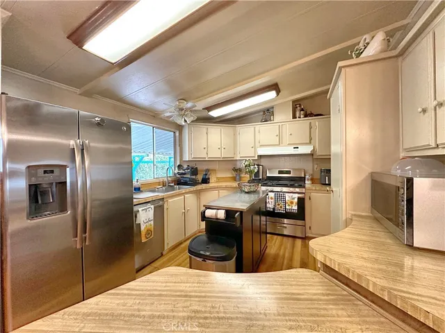 a kitchen with granite countertop a refrigerator stove and oven