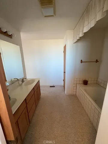 a bathroom with a tub sink and mirror