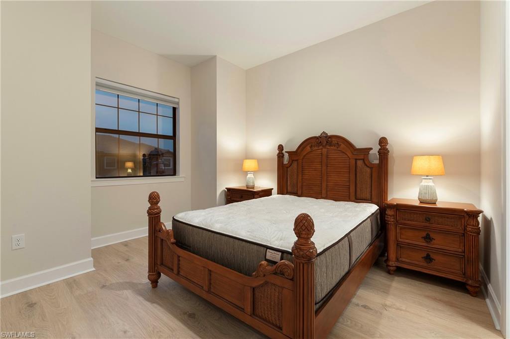 15328 Lucerna Street, Unit 202 Naples, FL 34114 - Photo 18 of 32 a bed sitting in a bedroom and lamp