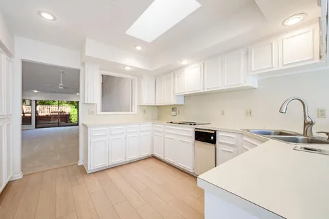 a kitchen with granite countertop a sink stainless steel appliances and cabinets