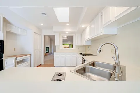 a kitchen with a sink a refrigerator and cabinets