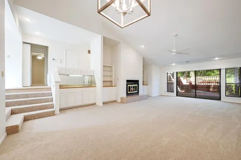 a view of an empty room with a fireplace and a large window
