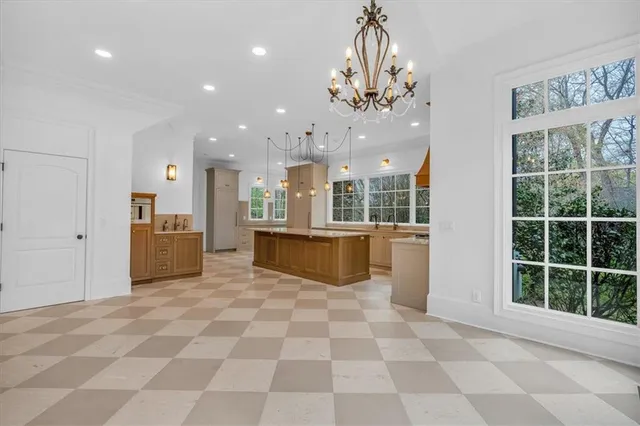 a large kitchen with stainless steel appliances kitchen island granite countertop a refrigerator and a stove top oven