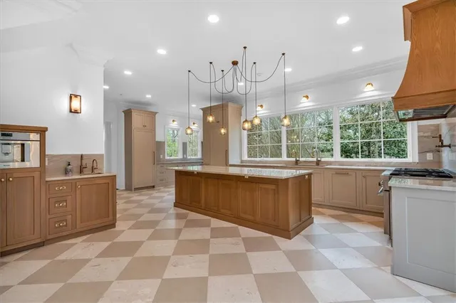 a view of a big room with kitchen and chandelier fan