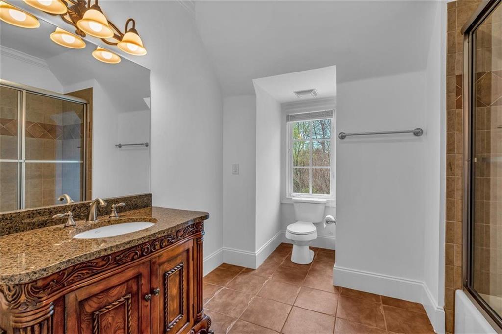 115 Mount Paran Ridge Atlanta, GA 30327 - Photo 50 of 85 a bathroom with a granite countertop sink a toilet and a mirror
