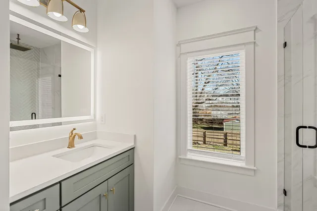 a bathroom with a sink a vanity and a window
