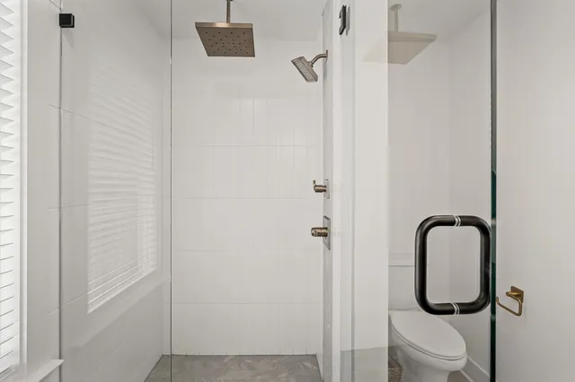 a bathroom with a granite countertop toilet and a sink