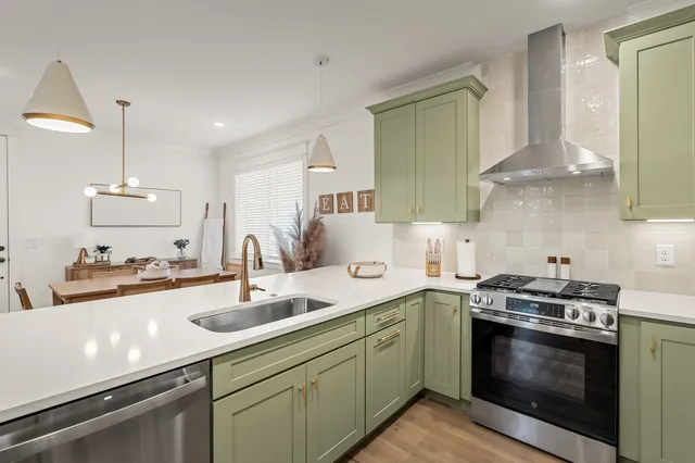 a kitchen with stainless steel appliances a sink stove and cabinets