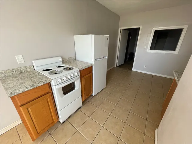 a kitchen with stainless steel appliances granite countertop a stove a refrigerator and a cabinets