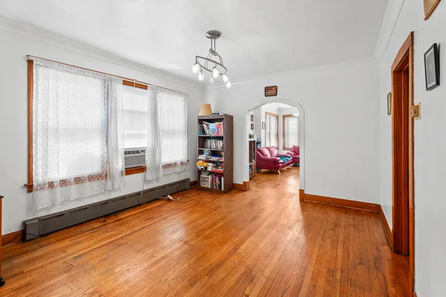 a view of a room with wooden floor and a ceiling fan