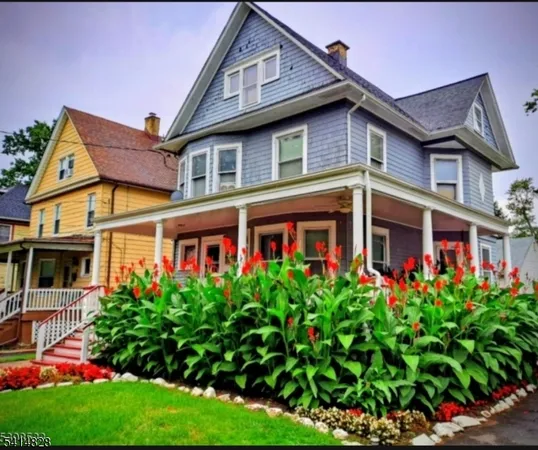 a front view of residential houses with yard and green space