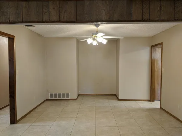 an empty room with windows and fireplace