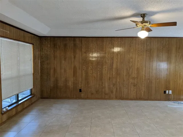 an empty room with windows and chandelier