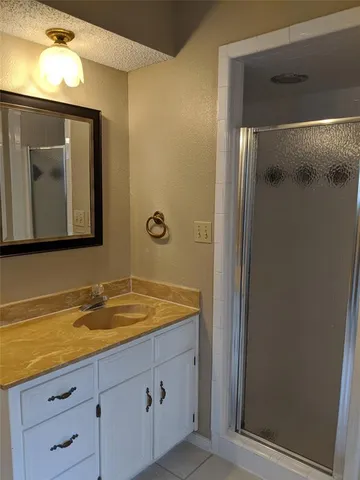a bathroom with a granite countertop sink toilet and mirror