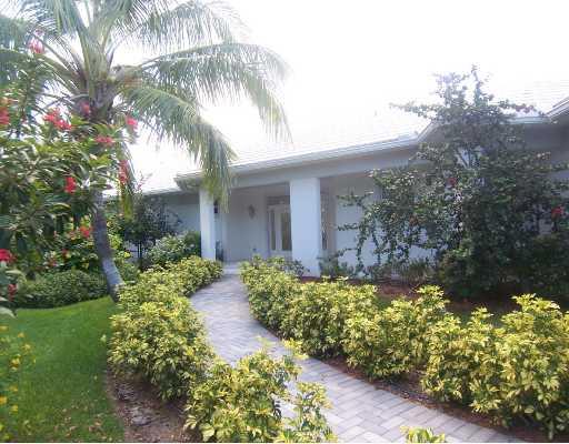 260 Southeast Cardinal Way Stuart, FL 34996 - Photo 1 of 8 a front view of a house with a yard and a garden