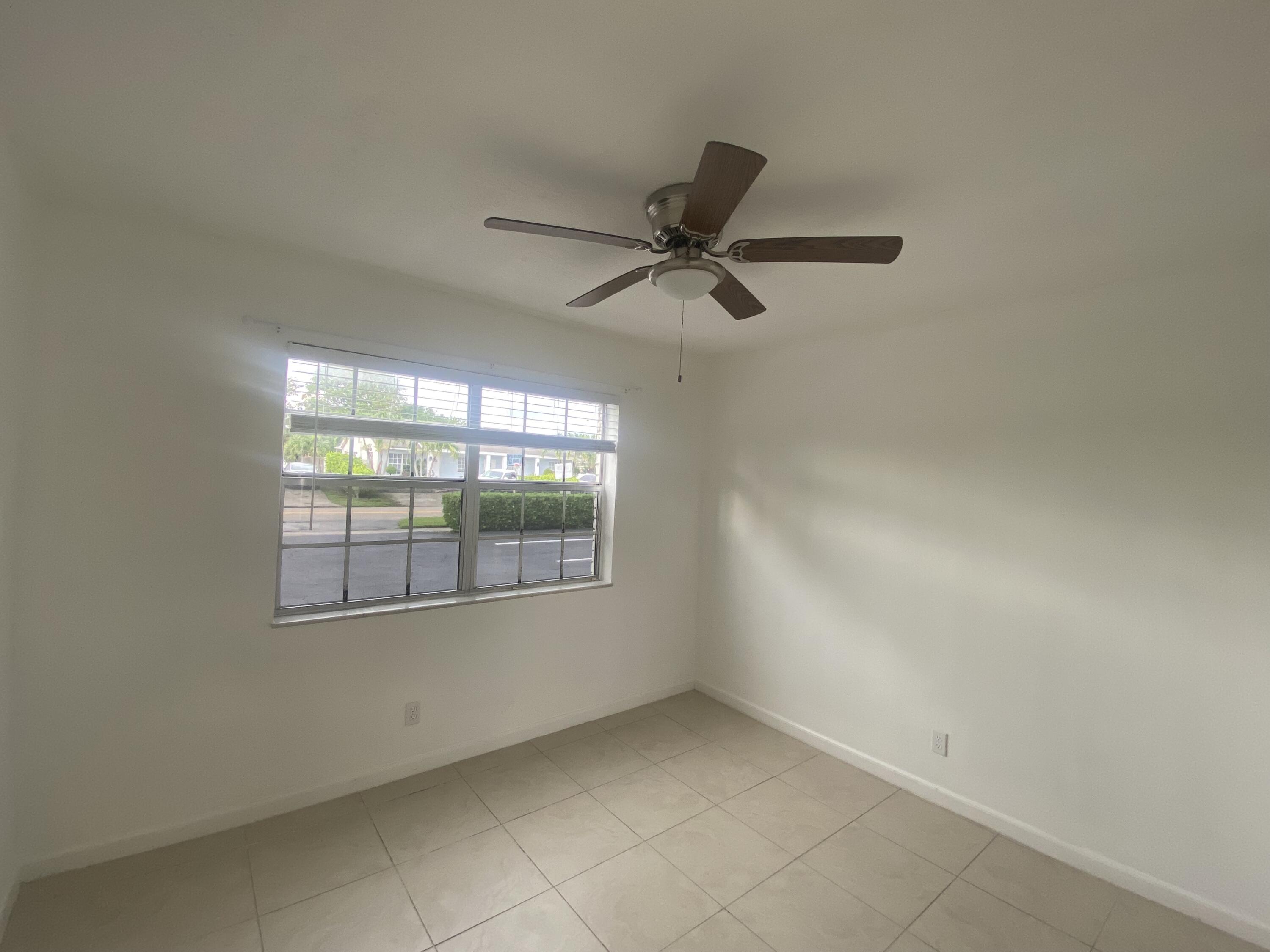 298 Southwest 6th Street, Unit 109 Boca Raton, FL 33432 - Photo 12 of 28 an empty room with a ceiling fan and window