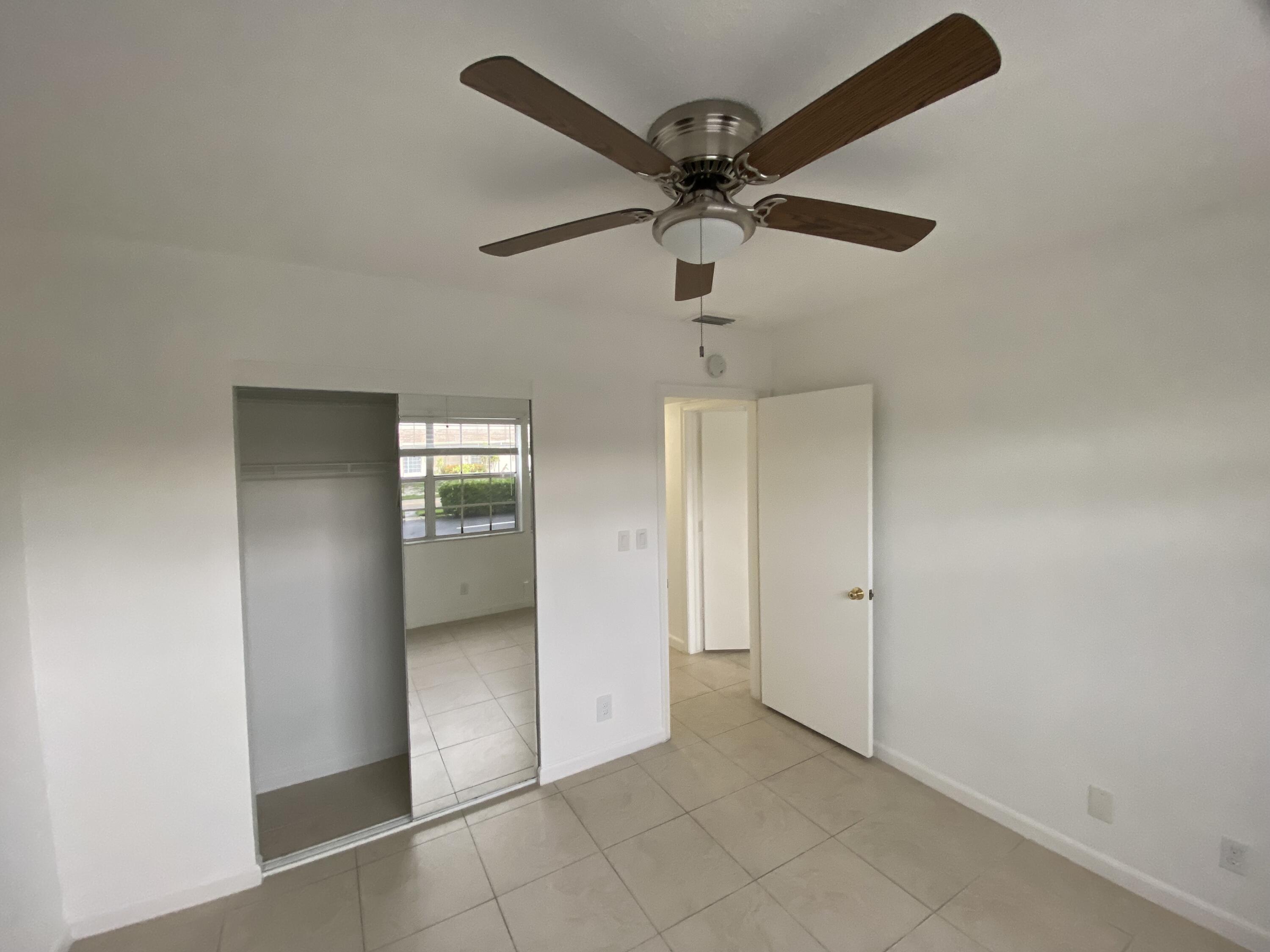 298 Southwest 6th Street, Unit 109 Boca Raton, FL 33432 - Photo 13 of 28 en empty room with closet and a ceiling fan