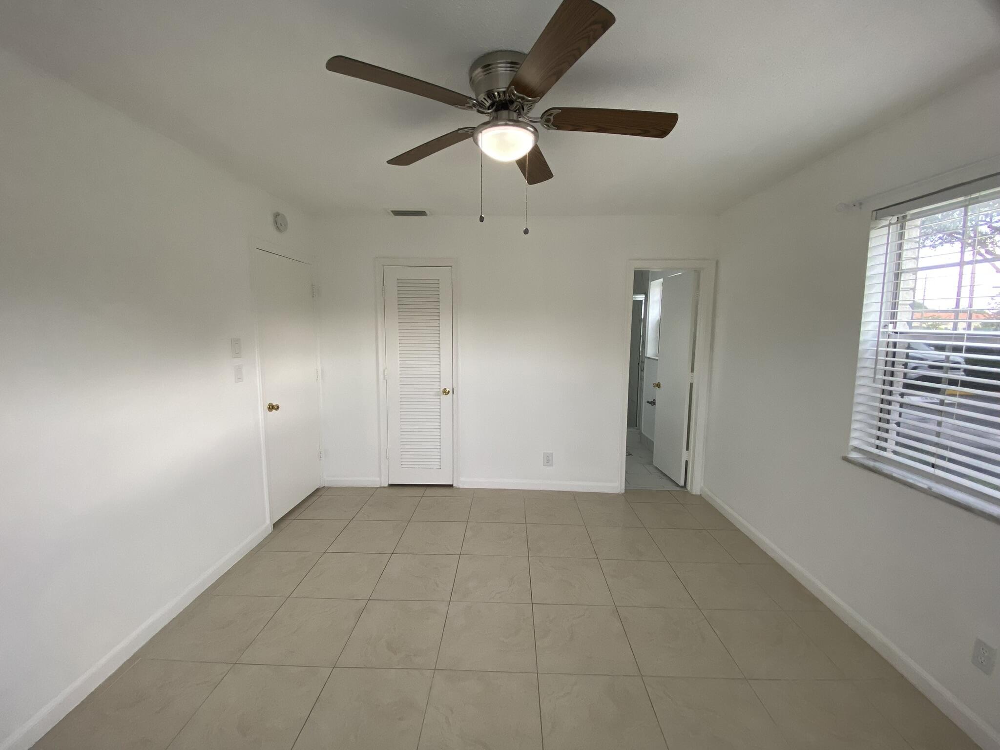 298 Southwest 6th Street, Unit 109 Boca Raton, FL 33432 - Photo 16 of 28 an empty room with windows and fan