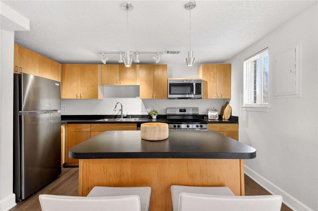 377 Ralph McGill Boulevard Northeast, Unit N Atlanta, GA 30312 - Photo 11 of 41 a kitchen with stainless steel appliances granite countertop a refrigerator a stove a sink dishwasher and white cabinets with wooden floor