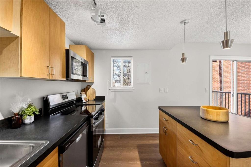 377 Ralph McGill Boulevard Northeast, Unit N Atlanta, GA 30312 - Photo 16 of 41 a kitchen with stainless steel appliances granite countertop a sink a stove cabinets counter space and a window