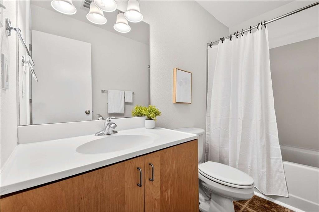 377 Ralph McGill Boulevard Northeast, Unit N Atlanta, GA 30312 - Photo 27 of 41 a bathroom with a sink a toilet a mirror and shower curtain