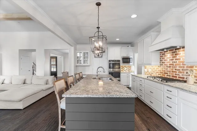 a large kitchen with sink a center island a stove and dining table