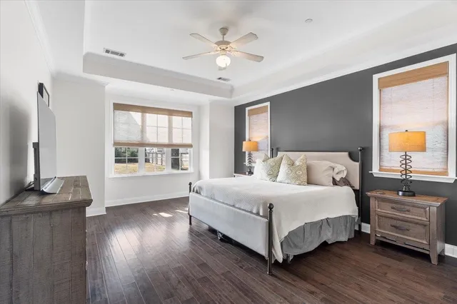 a bedroom with a bed and a flat tv screen on dresser