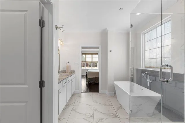 a spacious bathroom with a granite countertop sink a mirror and a bathtub