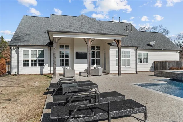 a backyard of a house with barbeque oven table and chairs