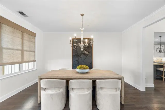 a dining room with table chairs and wooden floor